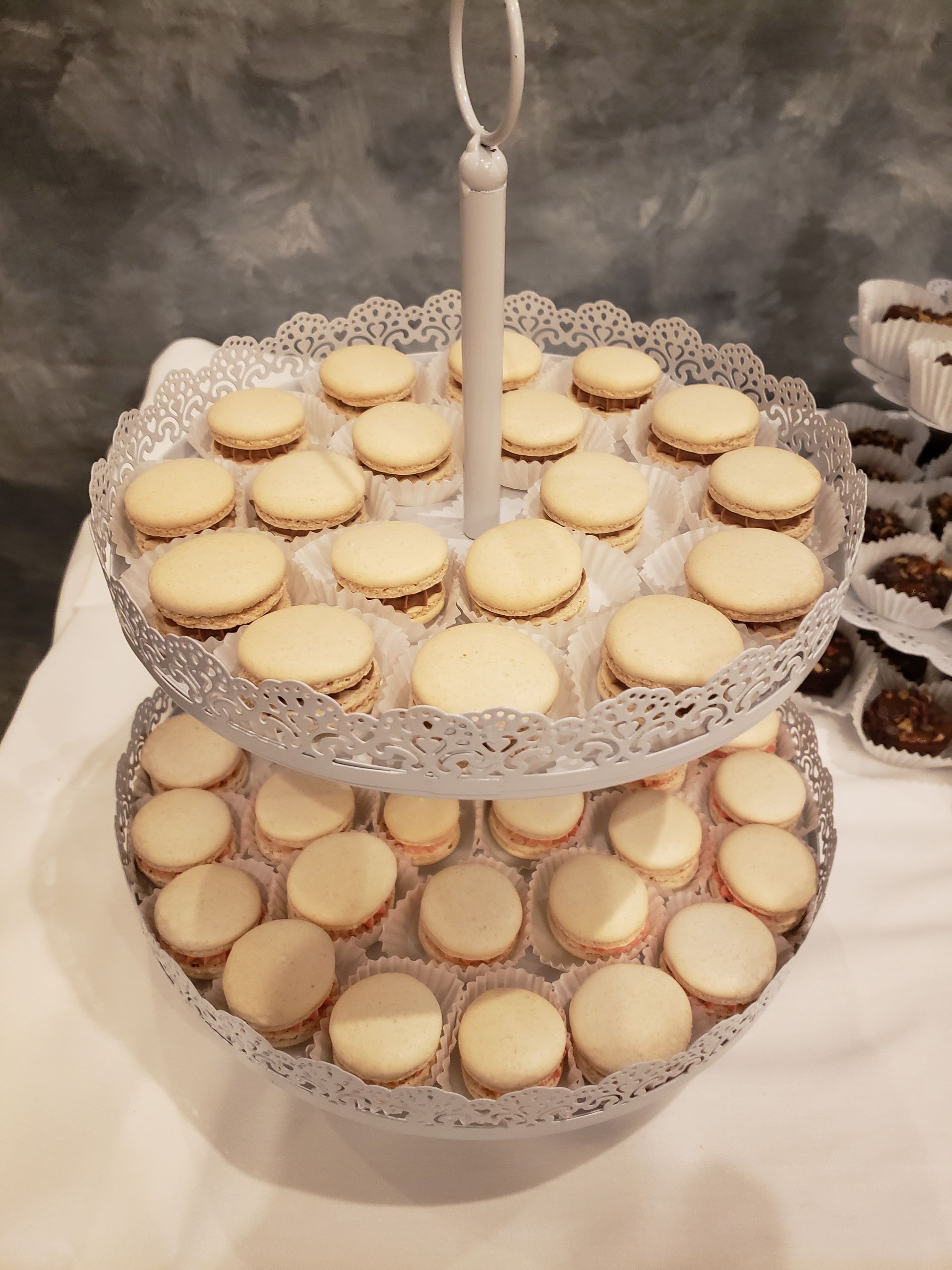 A three tiered tray filled with cookies on a table