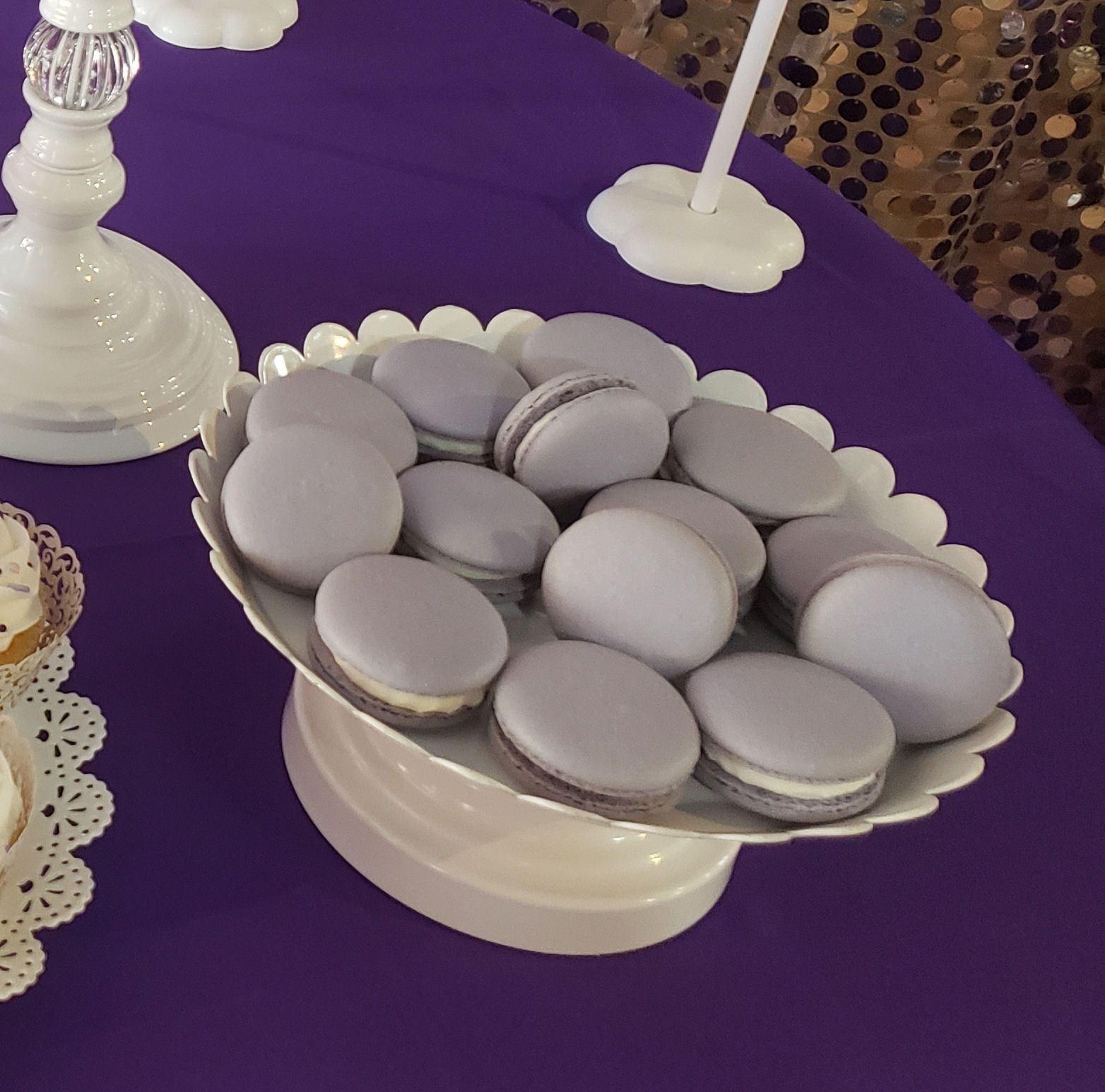 A bowl of macarons sits on a purple table
