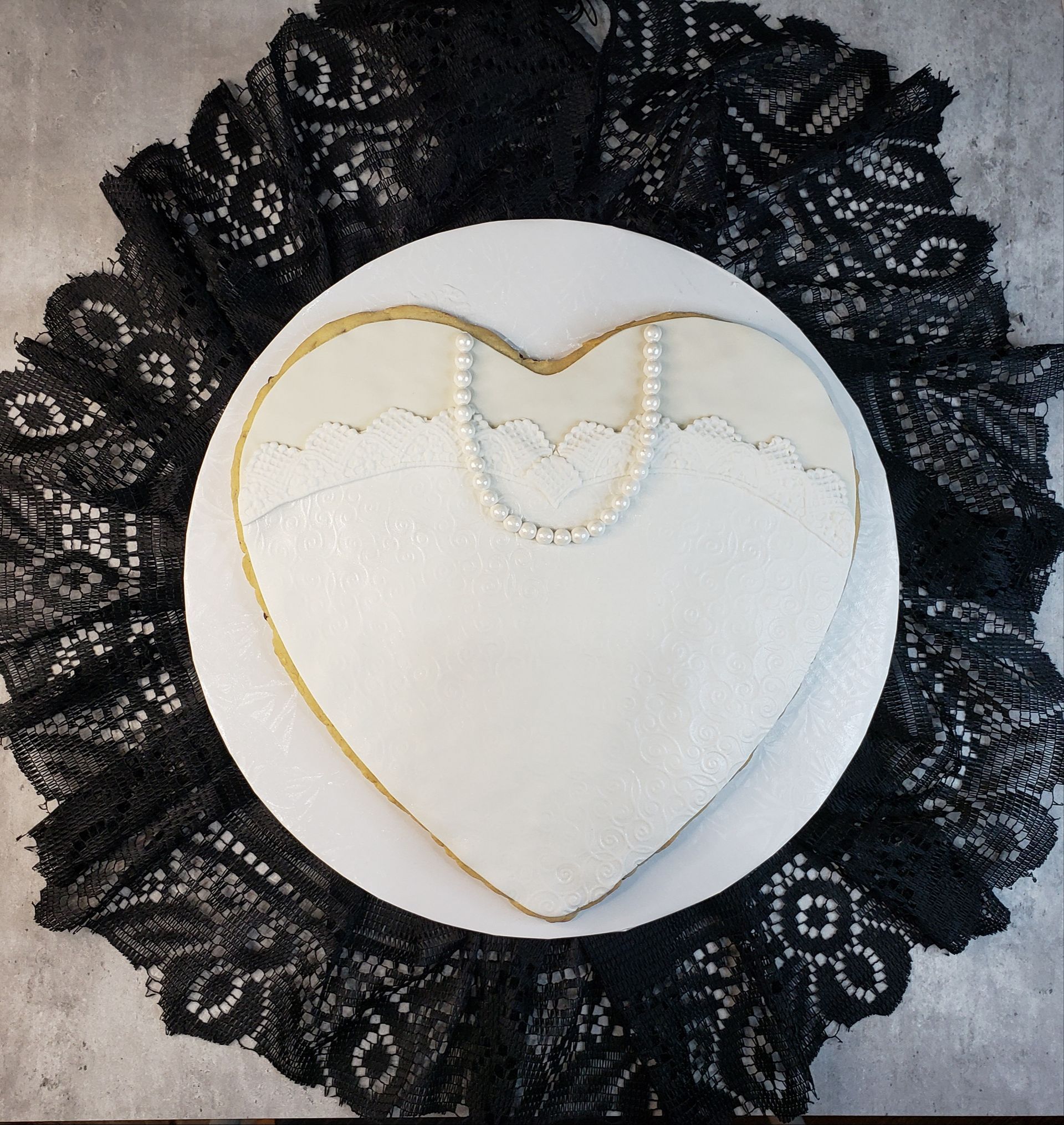 A heart shaped cookie with a pearl necklace on it