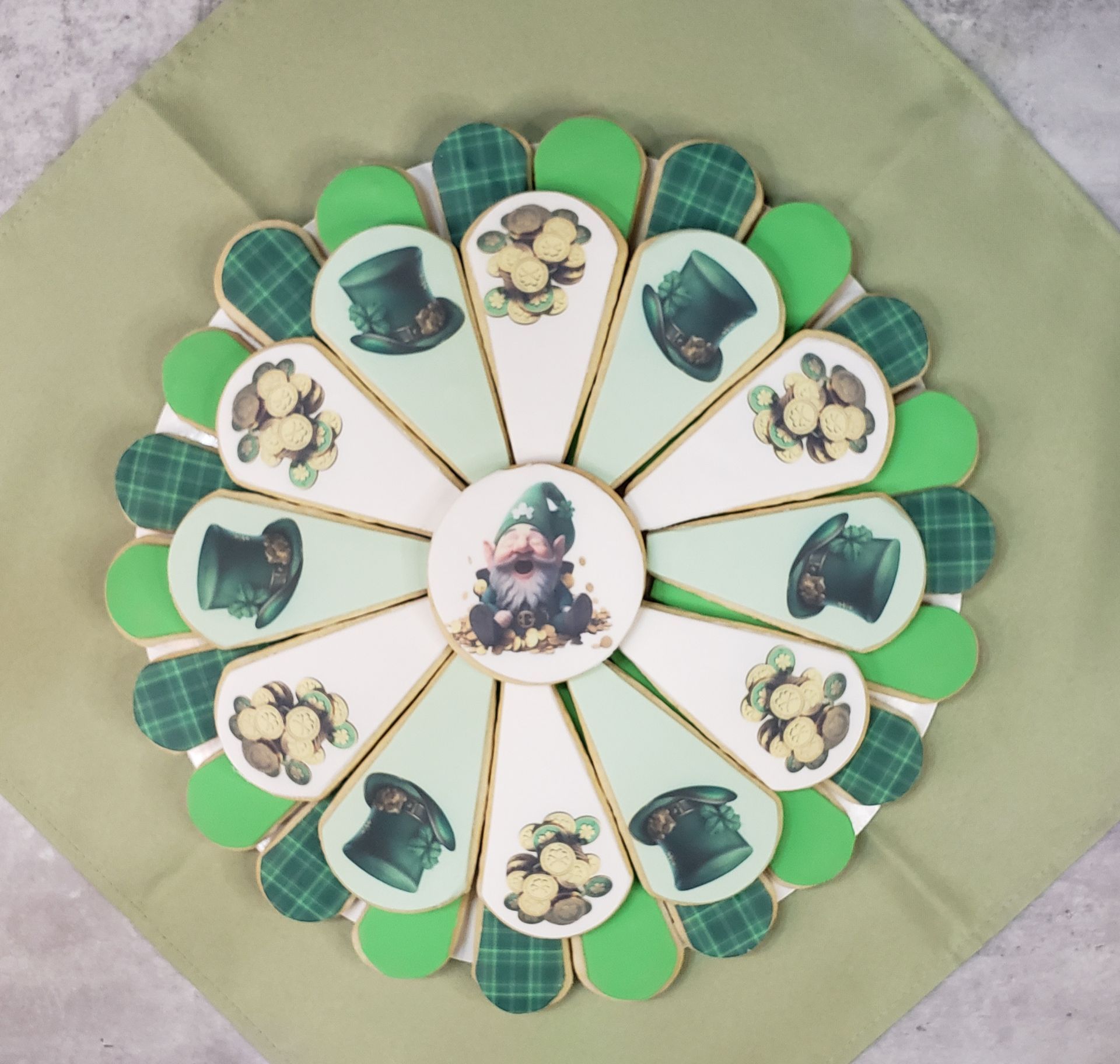 A circle of green and white cookies with leprechauns on them