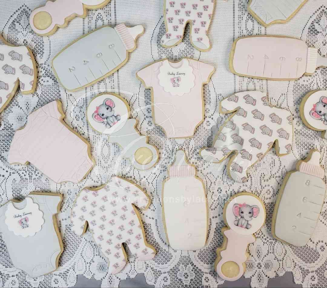 A bunch of baby shower cookies are sitting on a table.