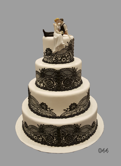 Four-tier white wedding cake with black lace-like bands and a bride and groom topper