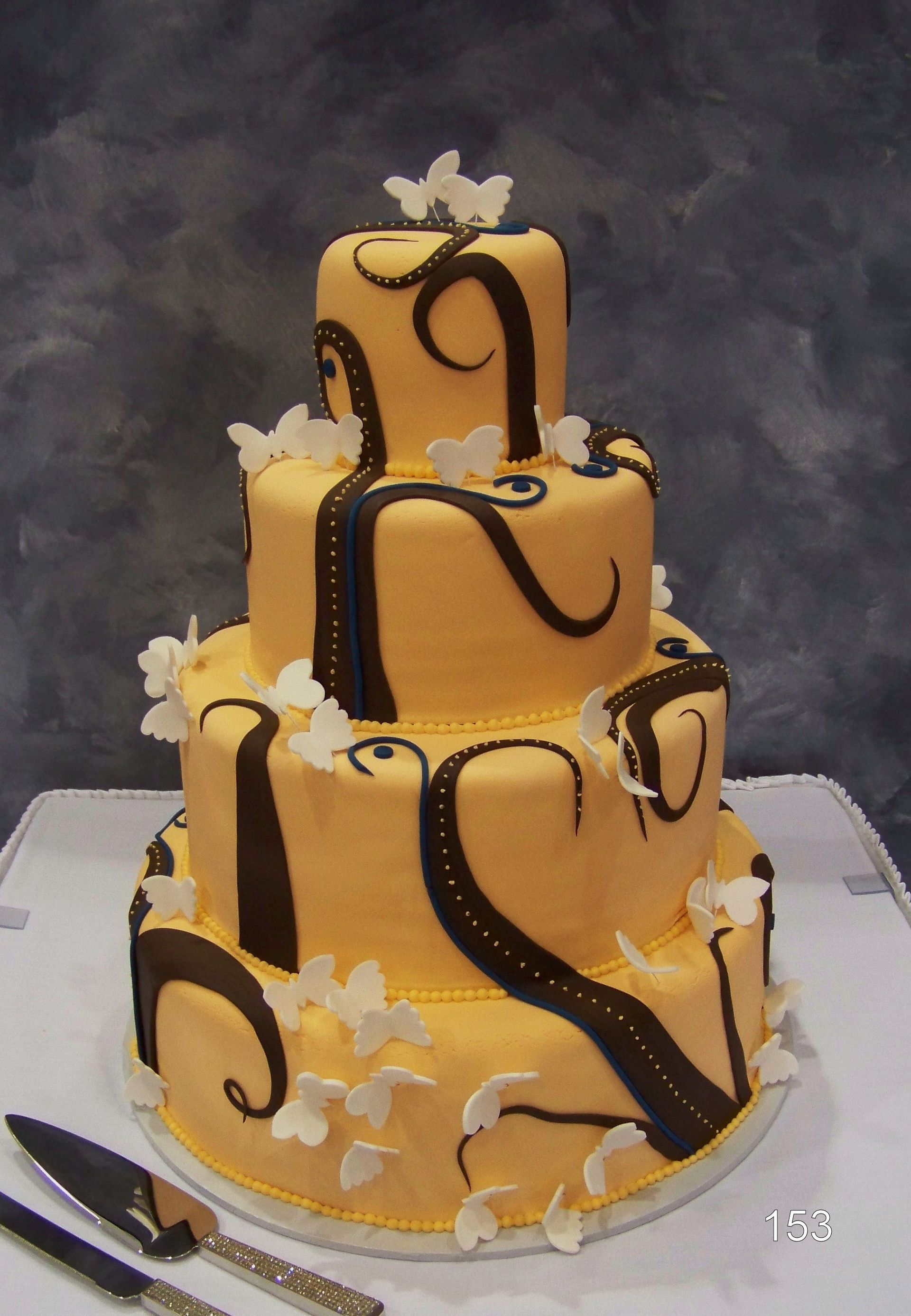 Three-tier orange cake with chocolate swirls and white flower decorations on a serving board
