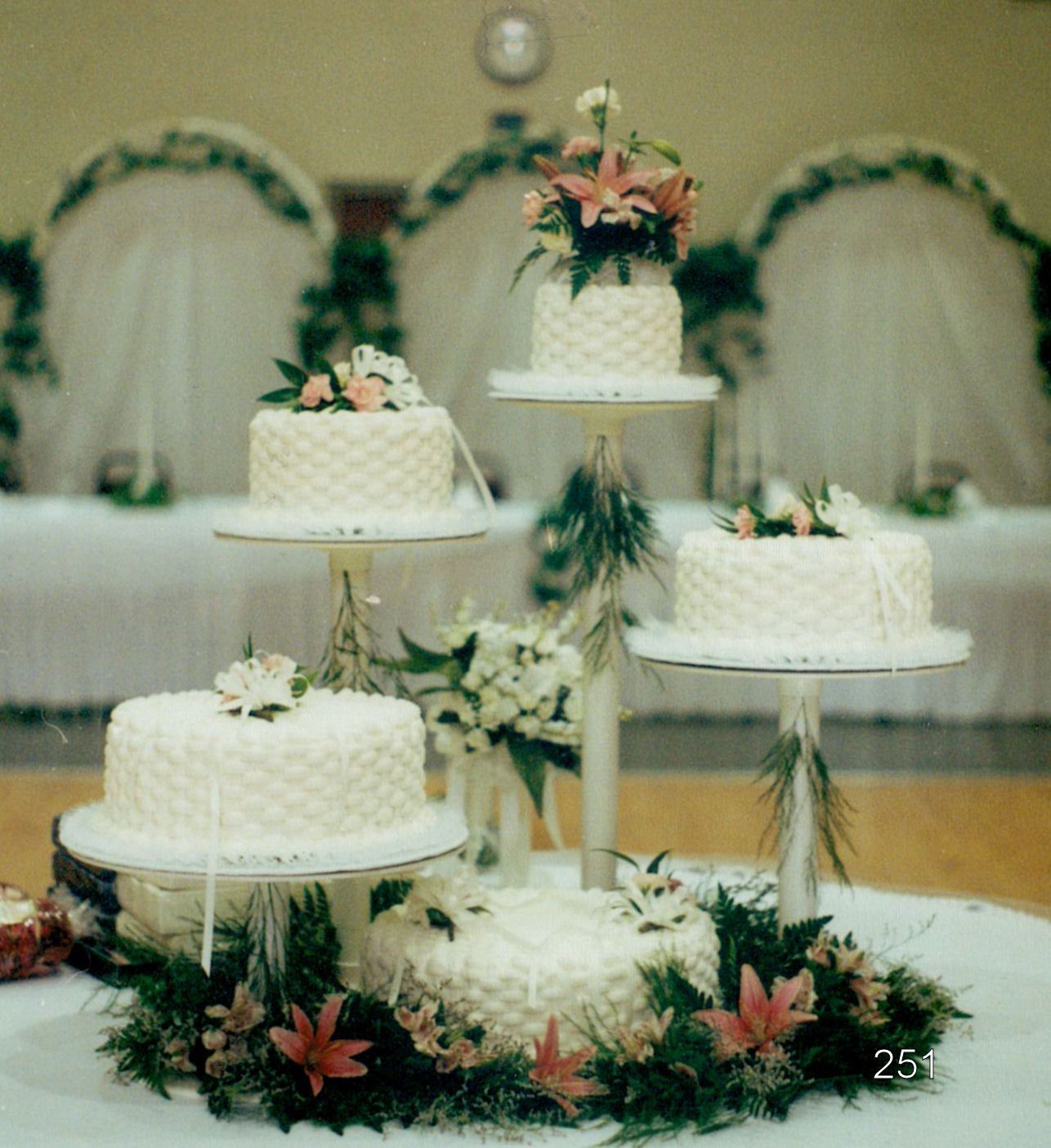 Tiered white wedding cakes with floral decorations on a banquet table