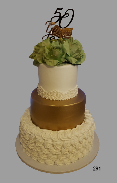 Four-tier gold and white celebration cake with green flowers and a “50” topper