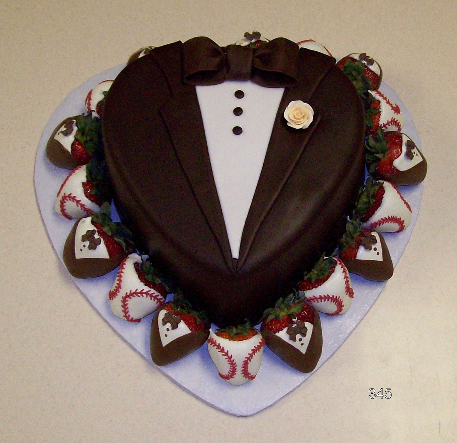 Heart-shaped chocolate tuxedo cake with strawberries and whipped cream on a white platter