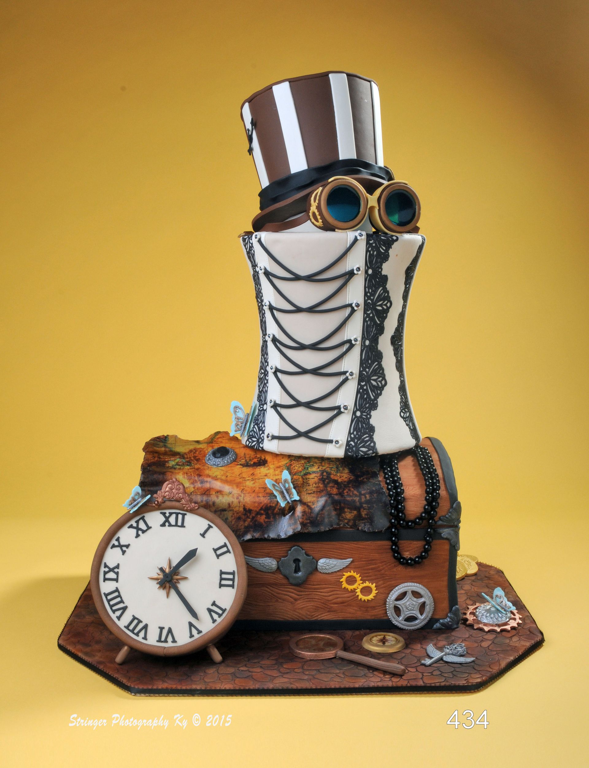 Steampunk-style clock sculpture with gears, goggles, and a tall striped top hat on a yellow background