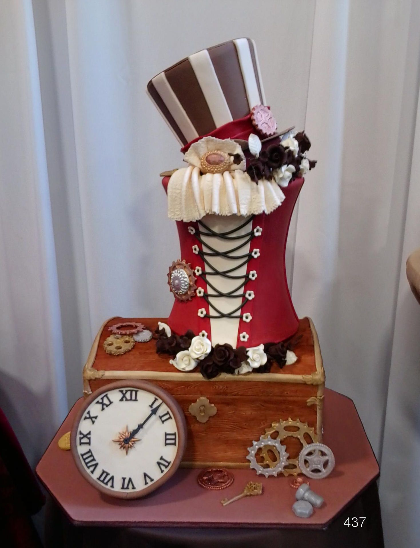 Decorative red-and-white top hat clock sculpture on a wooden base with gears and a small clock face