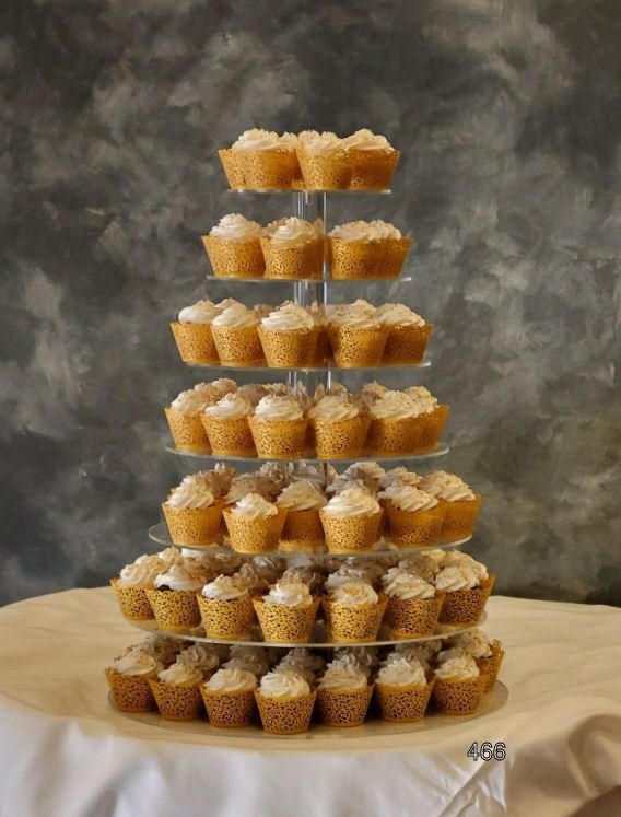 Tiered display of small dessert cups on a table against a gray backdrop