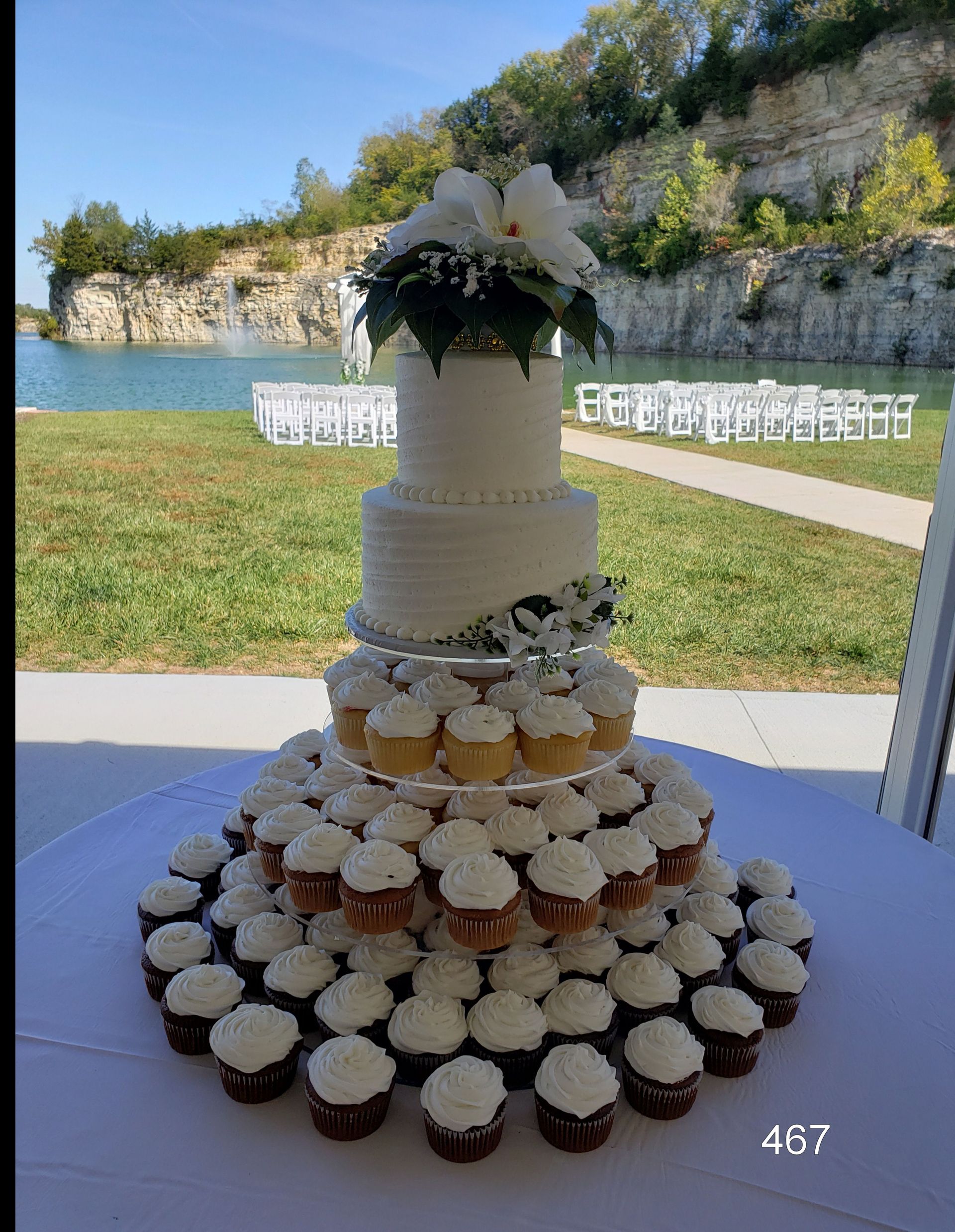 Tiered white and chocolate cupcake cake on a table at an outdoor wedding venue with cliff backdrop
