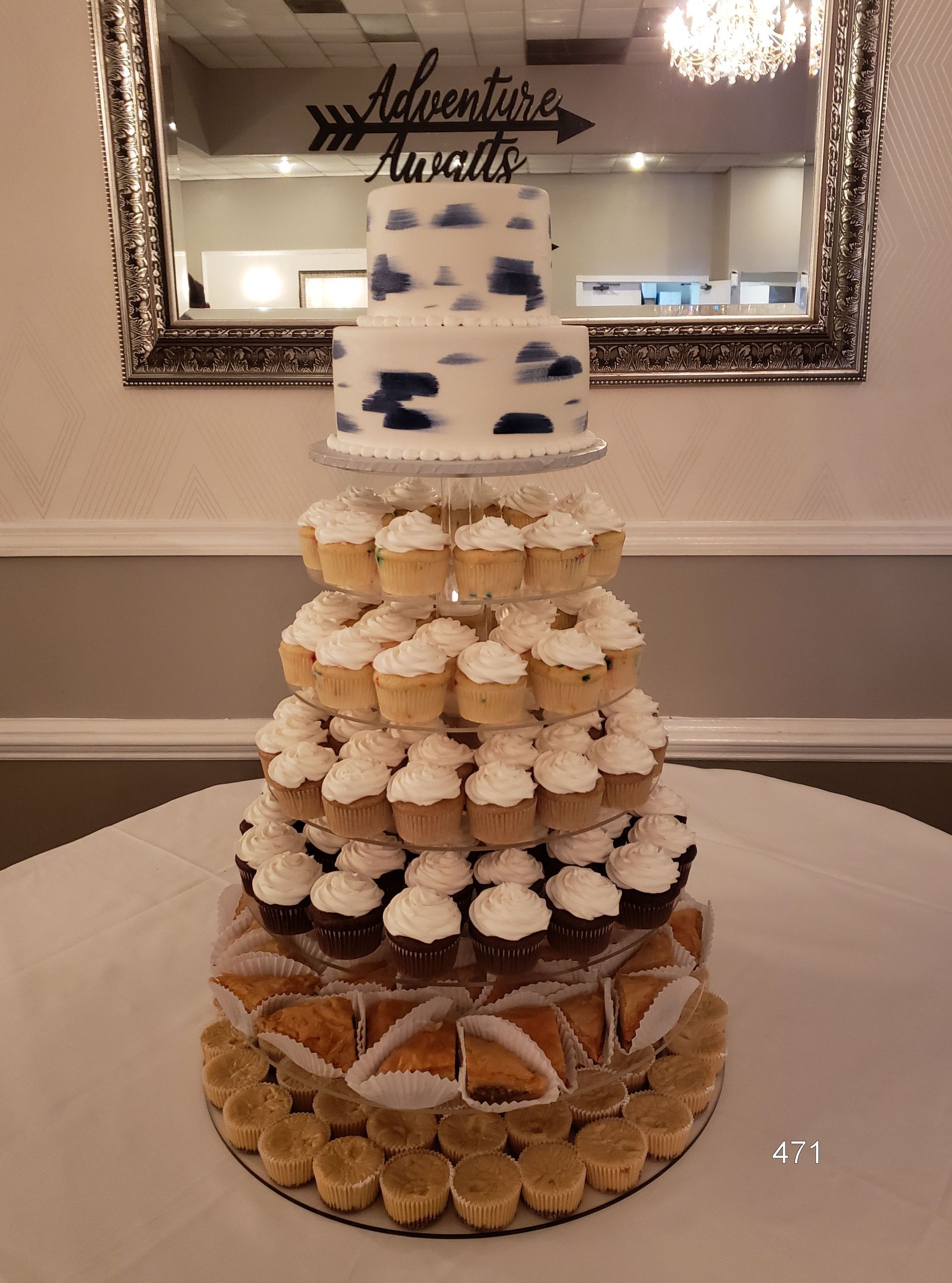 Tiered dessert tower with cream-filled pastries and a cake topper at a celebration table