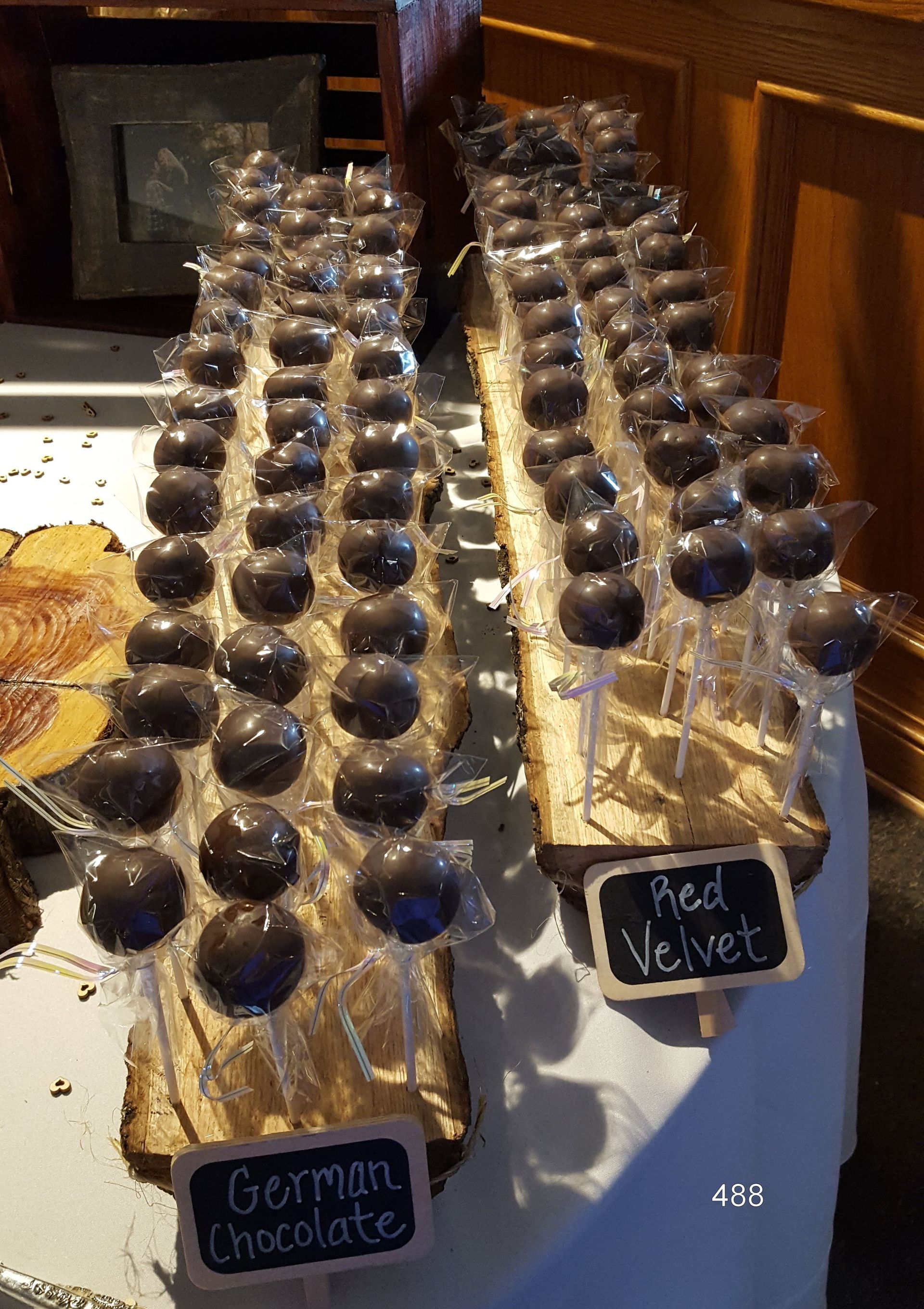 Chocolate truffles in clear cups on trays with labels reading “Gomm…” and “Red Velvet”
