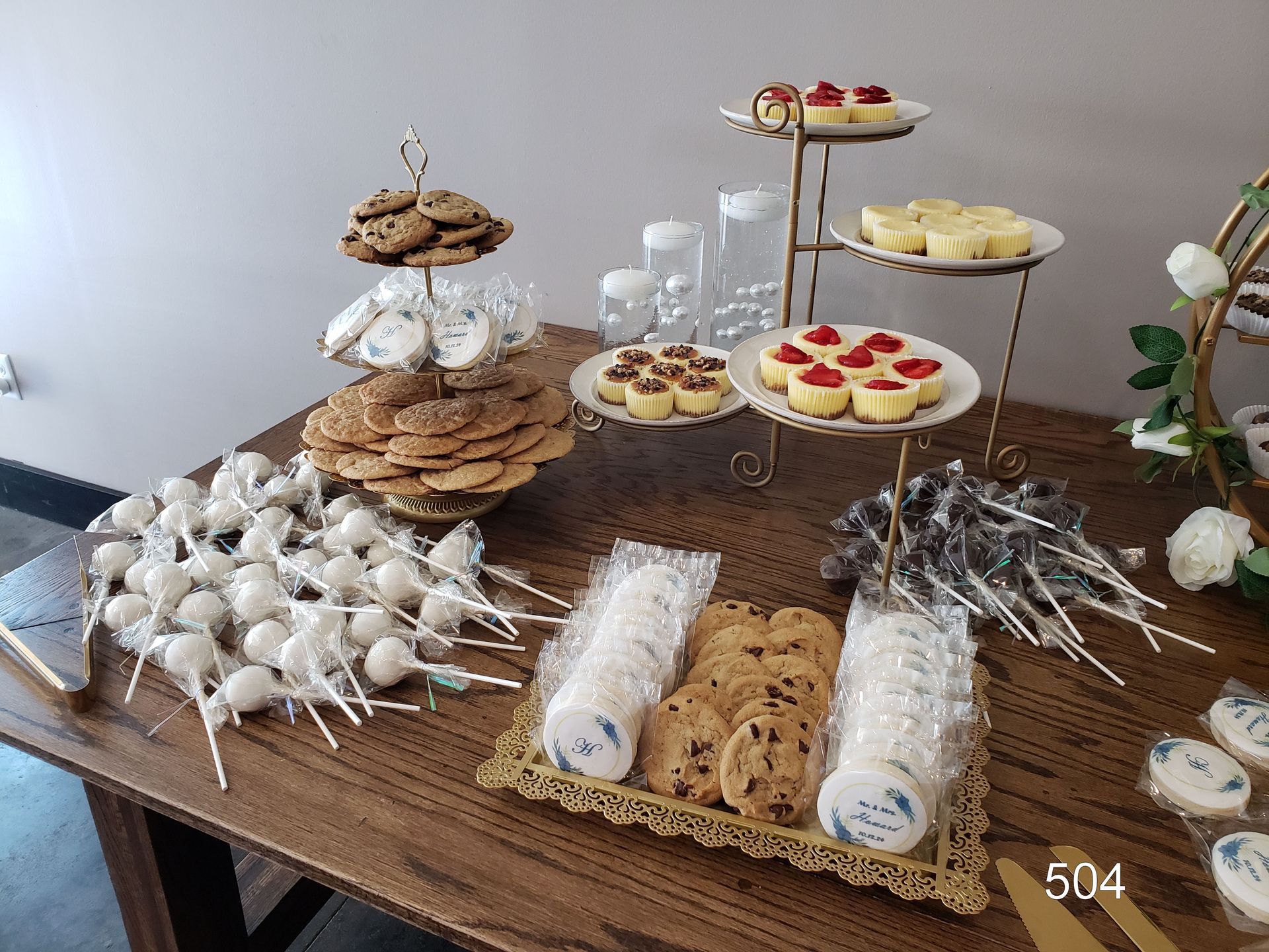 Dessert buffet with assorted cookies, pastries, and treats arranged on a table outdoors.