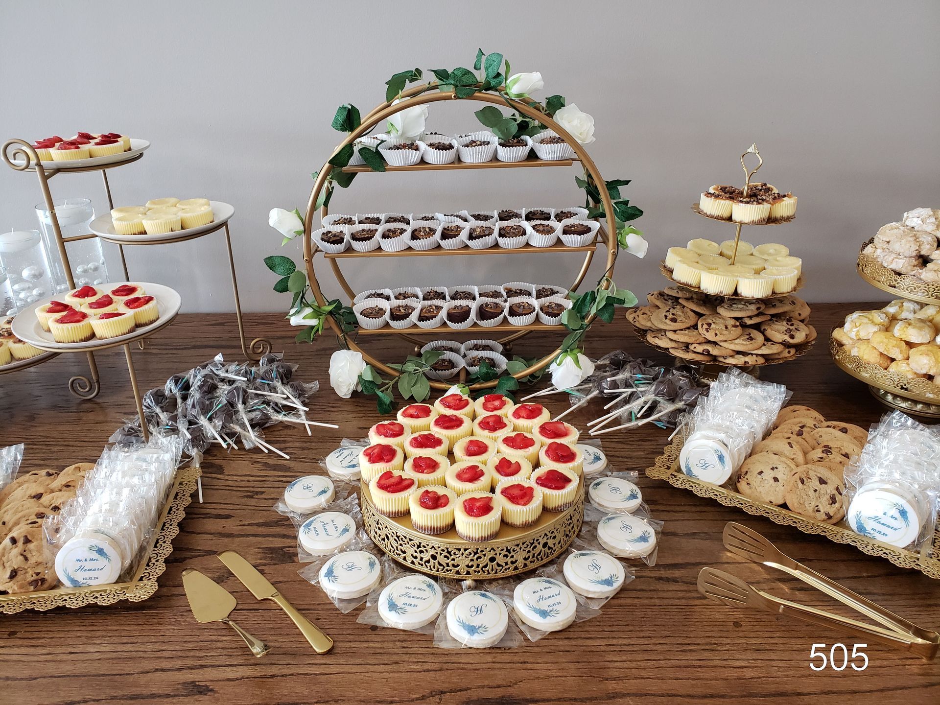 Dessert table with assorted cupcakes, cookies, and pastries on tiered stands and trays