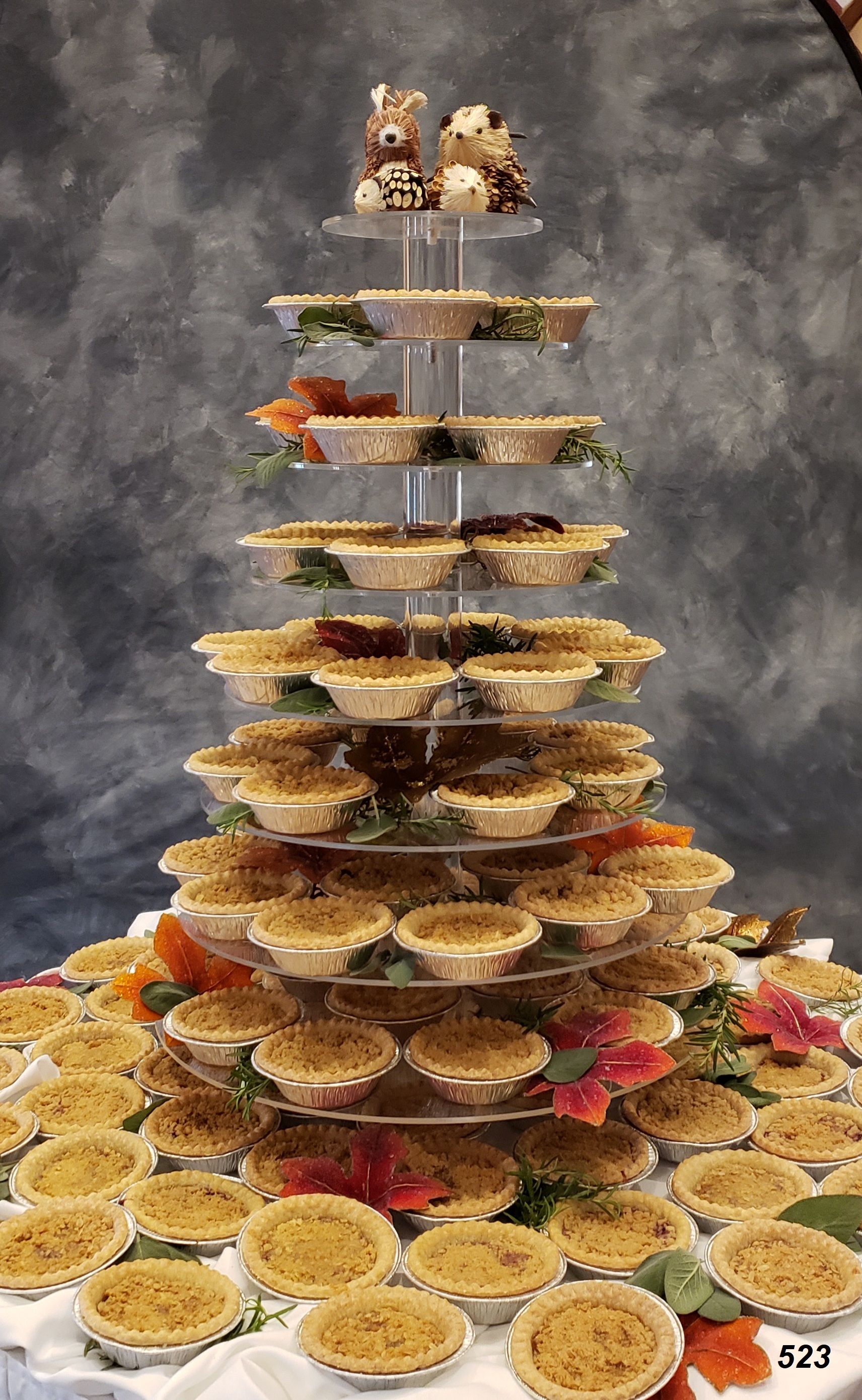Tiered dessert tower with stacked pastries and fruit on a patterned tablecloth