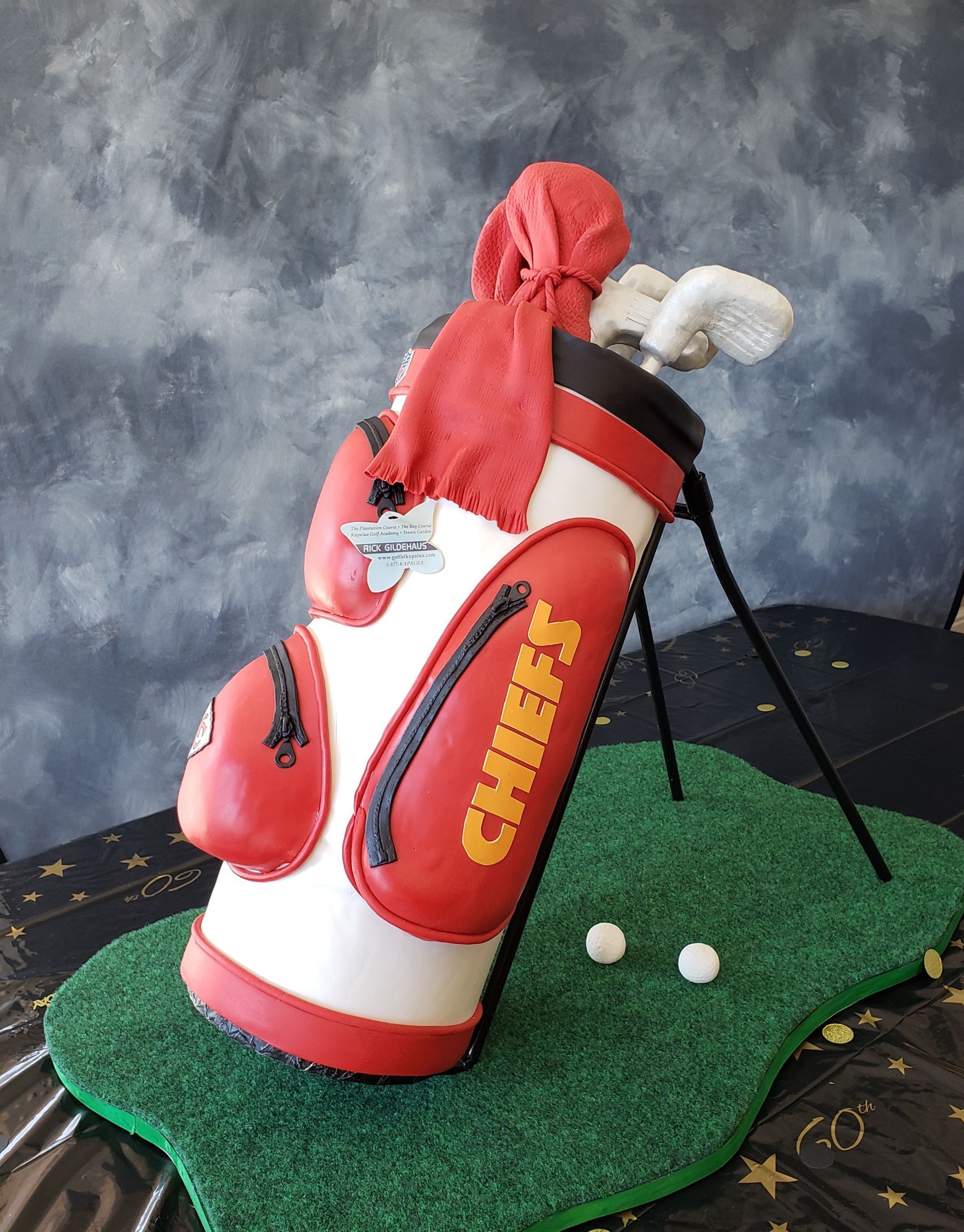 A red and white golf bag cake with the word chiefs on it