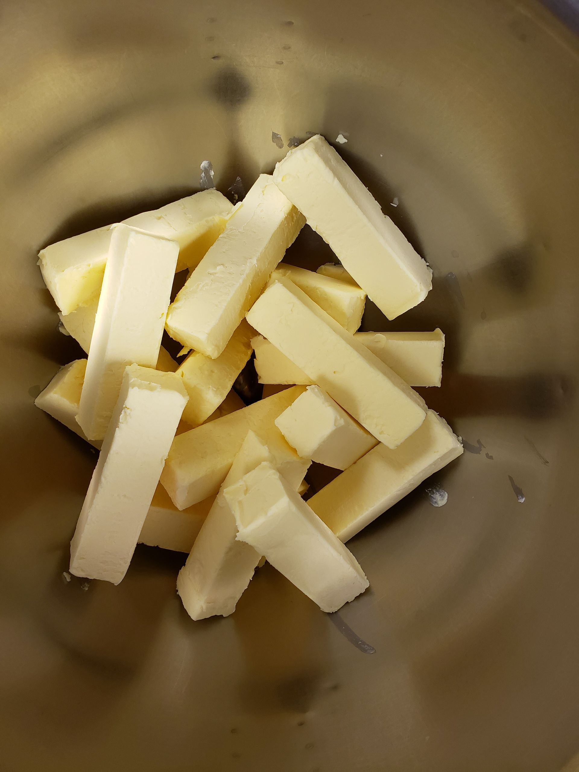 a metal bowl filled with pieces of butter