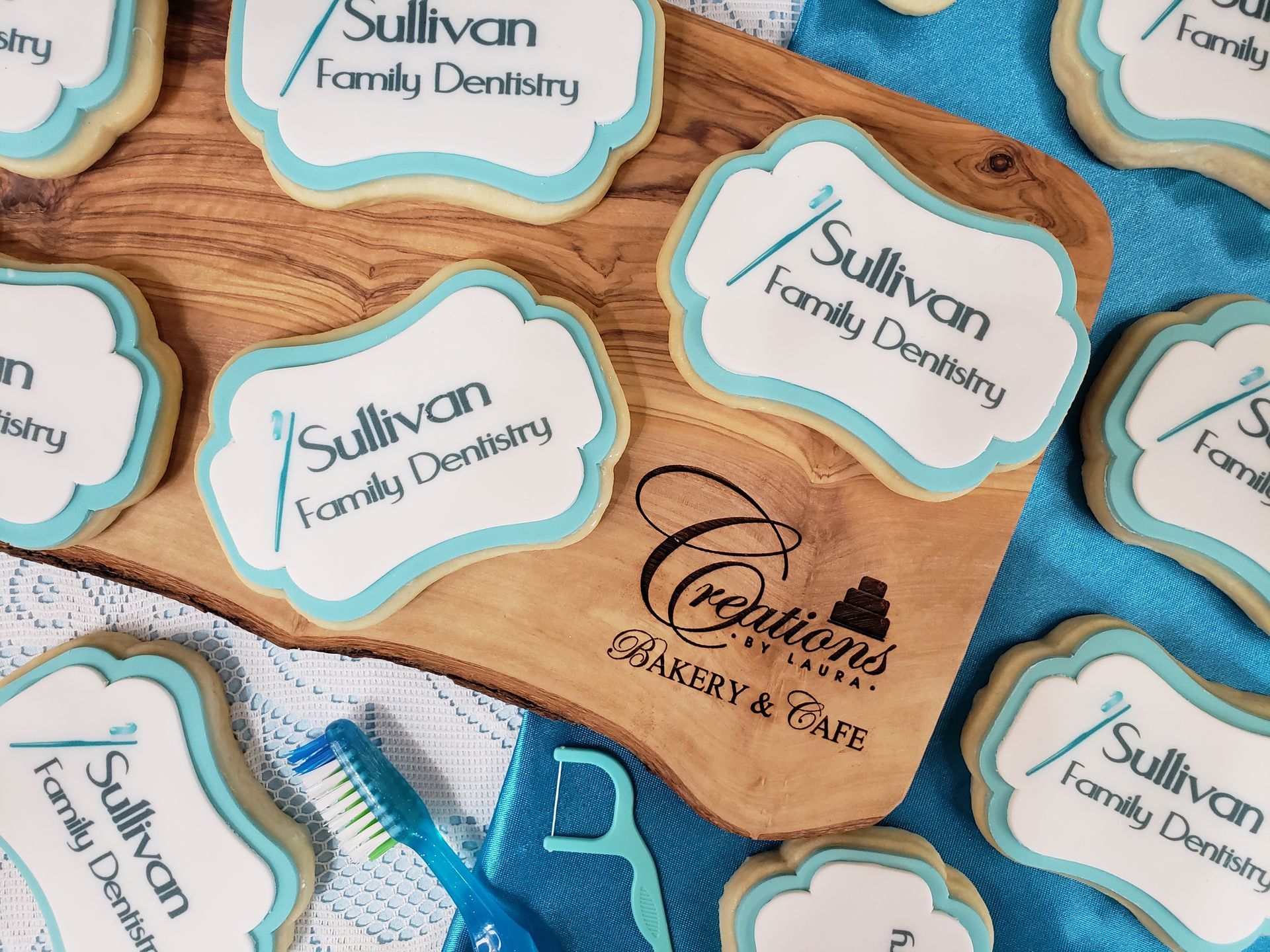 Assorted scalloped labels for Sullivan Family Dentistry and Forever Smile, in teal and peach on a wood background