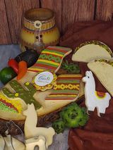 Assorted colorful cheeses and carved decorative cheese animals on a wooden table