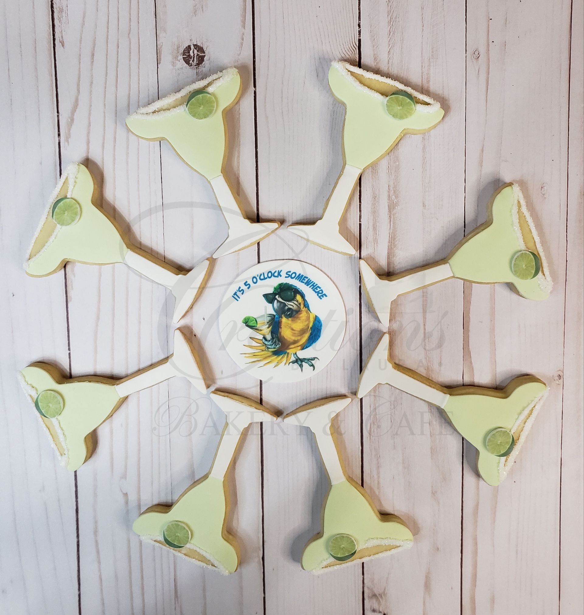 Eight-petaled white and green flower craft with a circular center on a light wood background