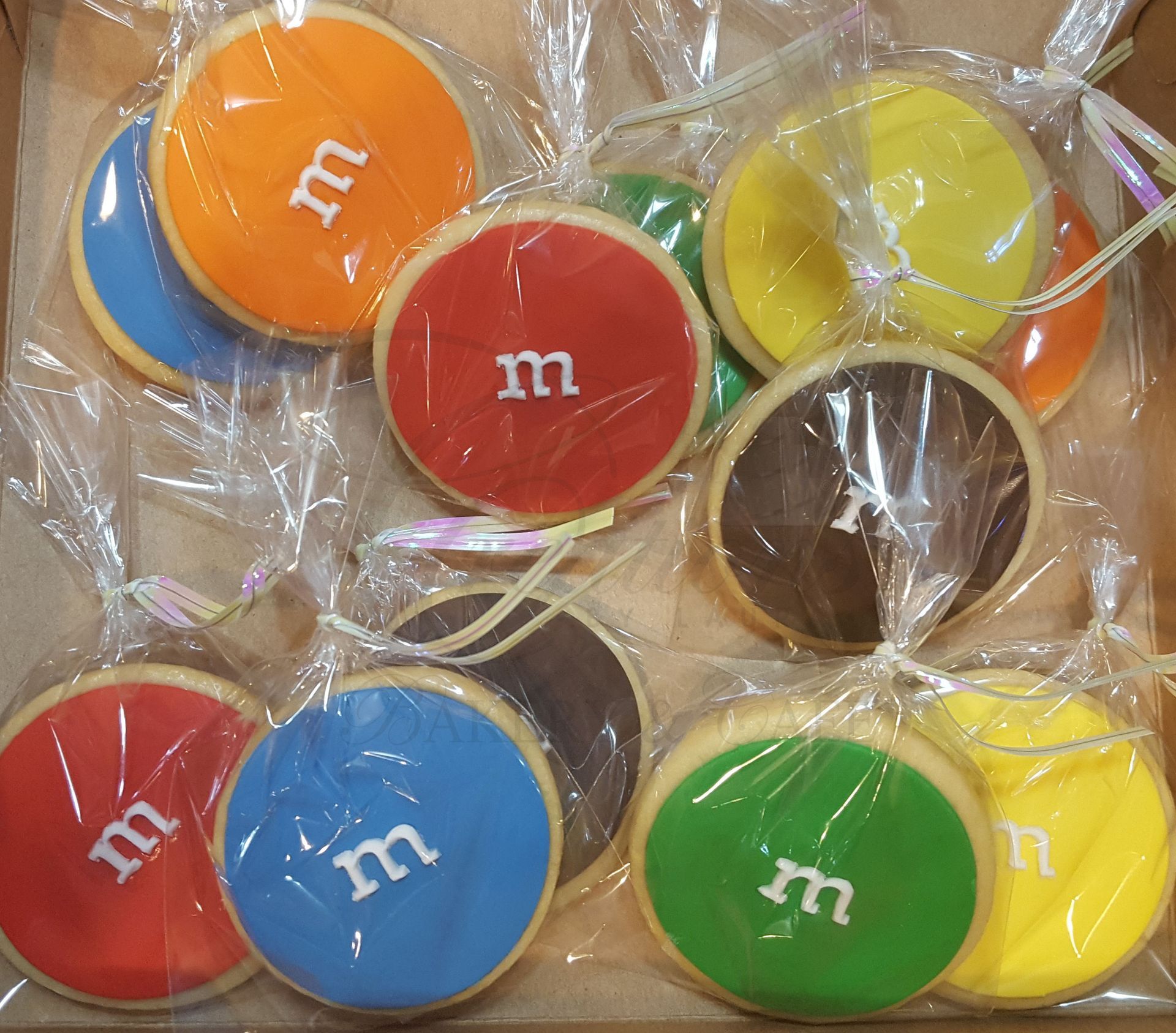 Colorful M&M candies in clear plastic wrappers, showing red, blue, green, yellow, orange, and brown pieces.
