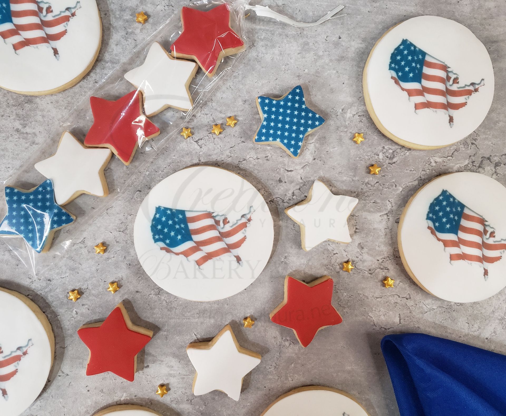 Patriotic sugar cookies with red, white, and blue stars and American flag designs on a gray surface