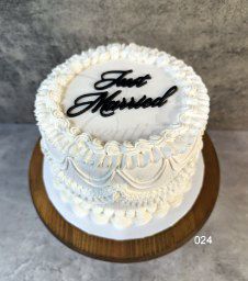 Round table set for a formal event, featuring floral centerpiece, gold accents, and transparent candle holders.