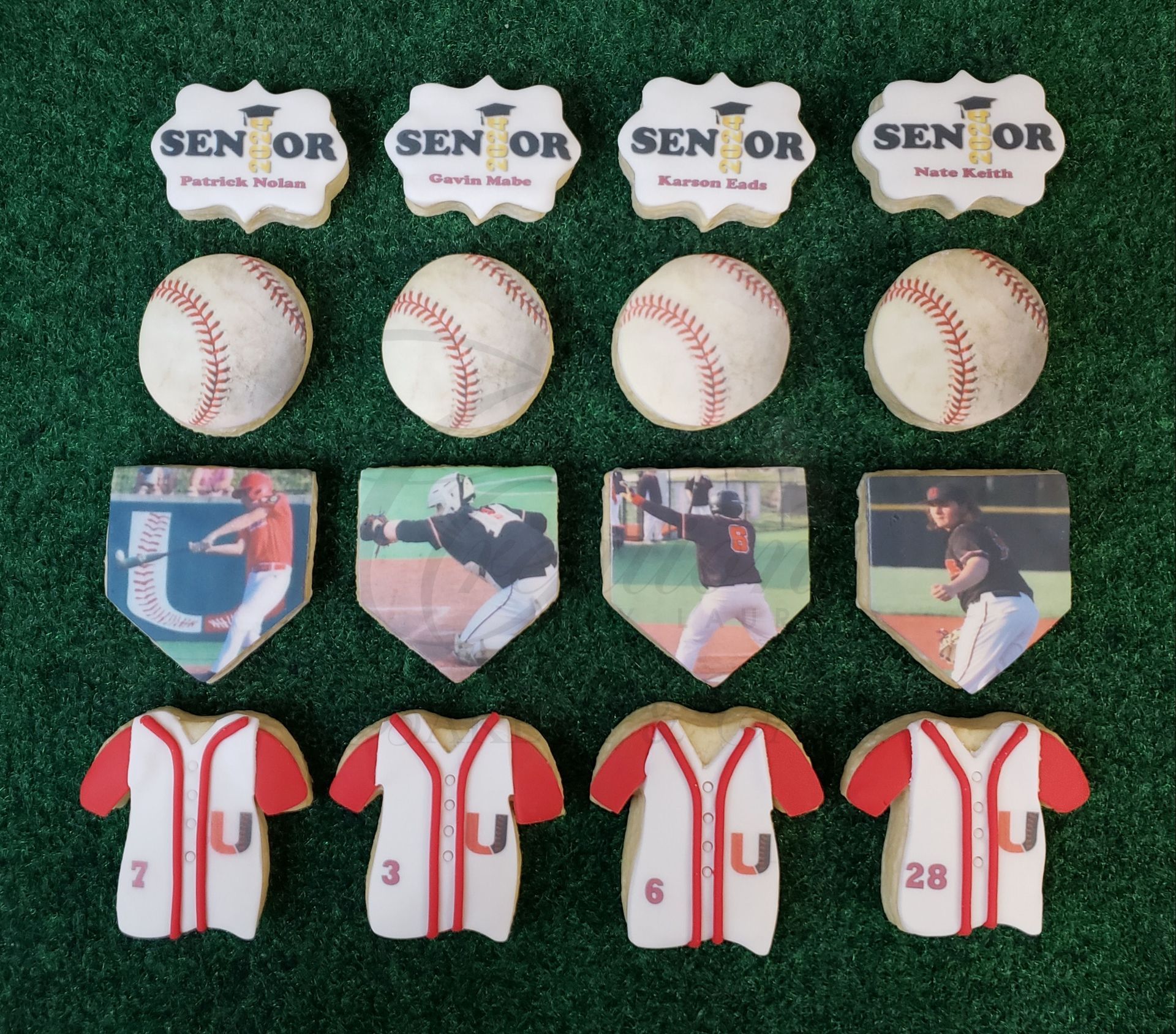 Baseball memorabilia arranged on green turf: four SENIOR pins, baseballs, shield cards, and white jerseys with red trim.