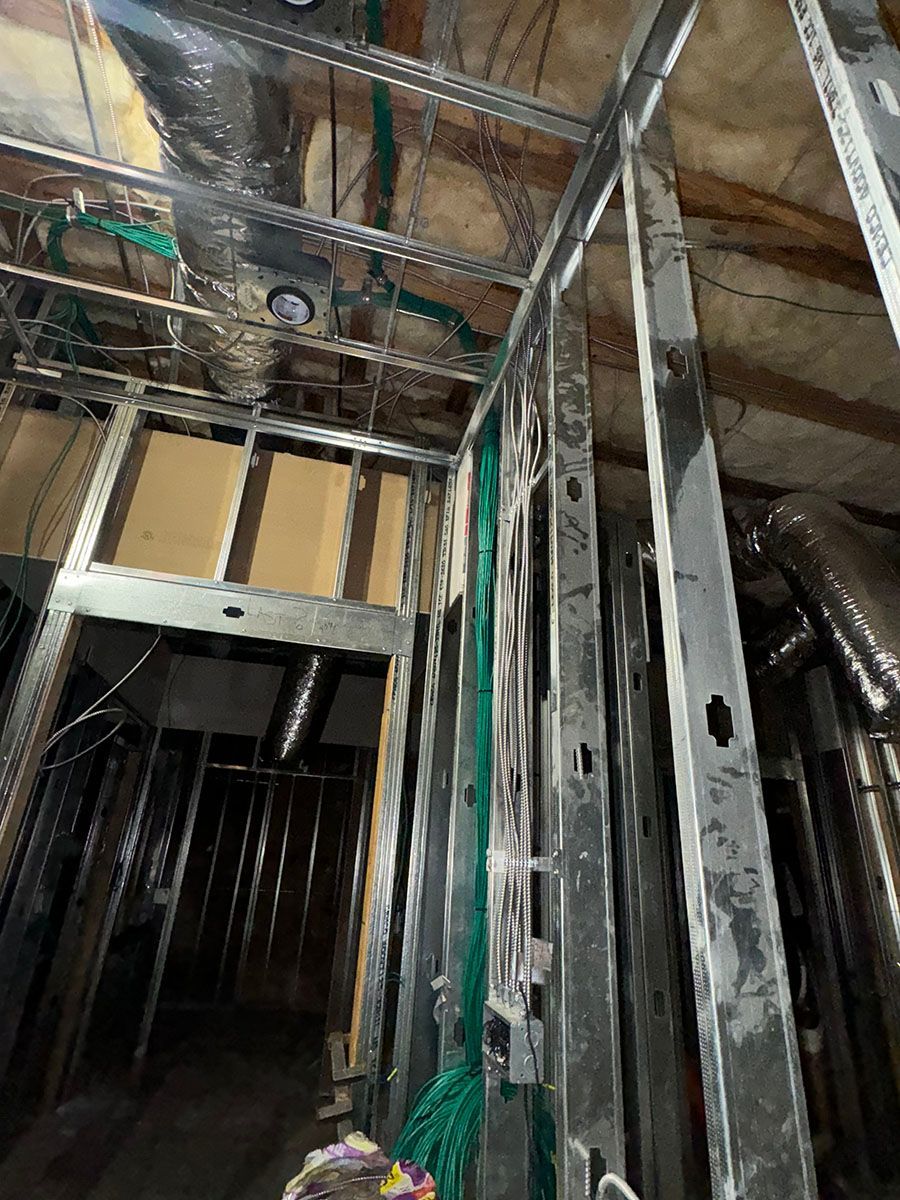 A building under construction with a lot of wires hanging from the ceiling.