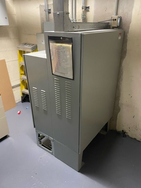 A gray metal cabinet is sitting on a blue floor in a room.