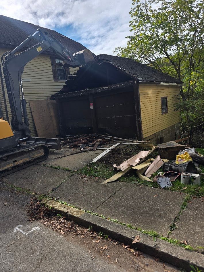 Damaged house with burned roof and debris strewn across the front yard and sidewalk.