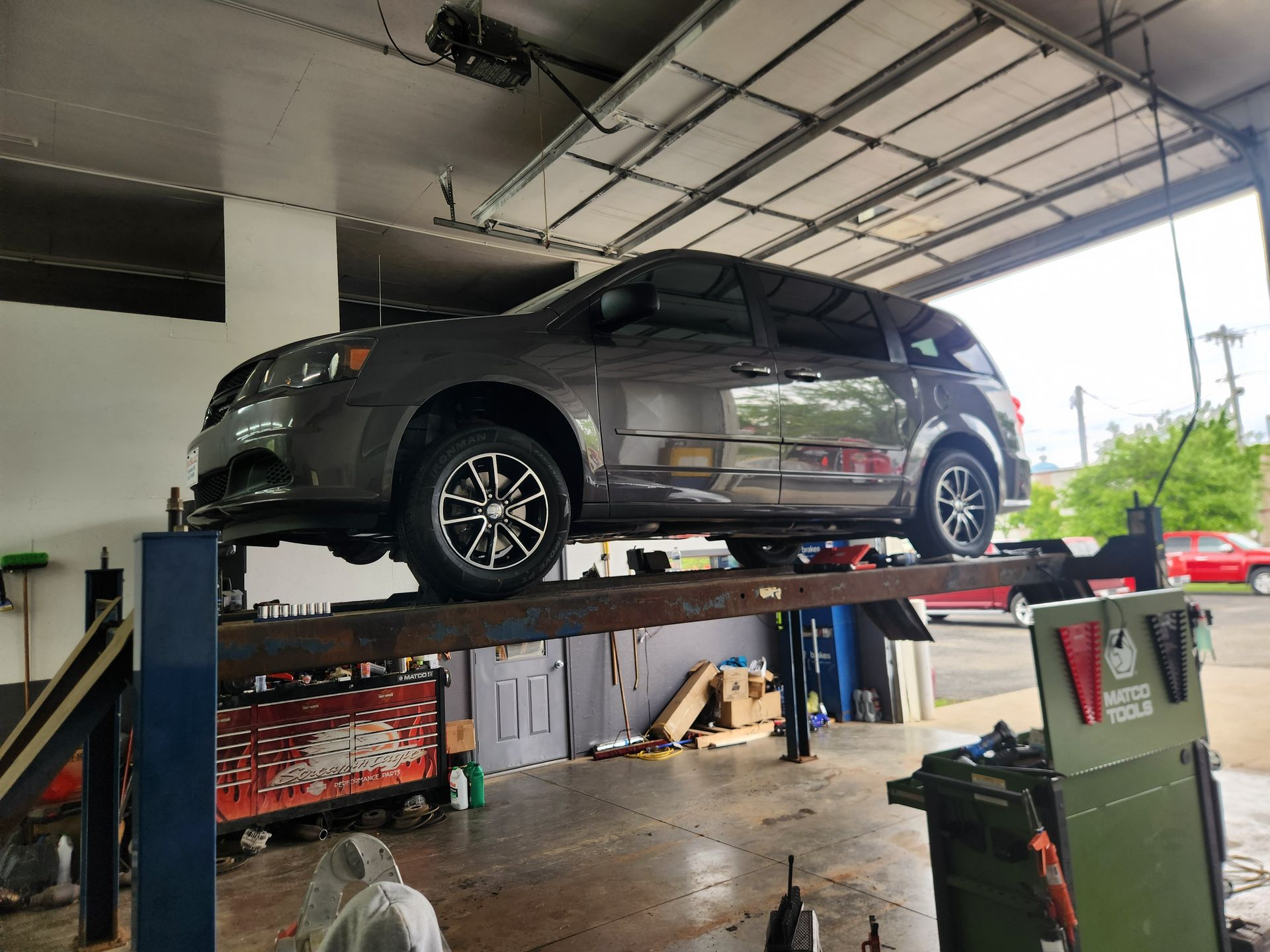 Gray SUV raised on a vehicle lift in a garage service bay
