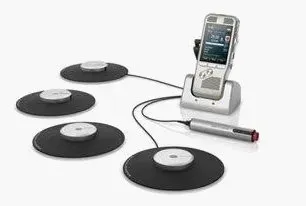 Cell phone docked, connected to four black pads and a microphone.