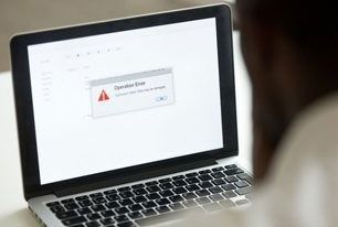 Person looking at laptop screen with "Operation Error" message.