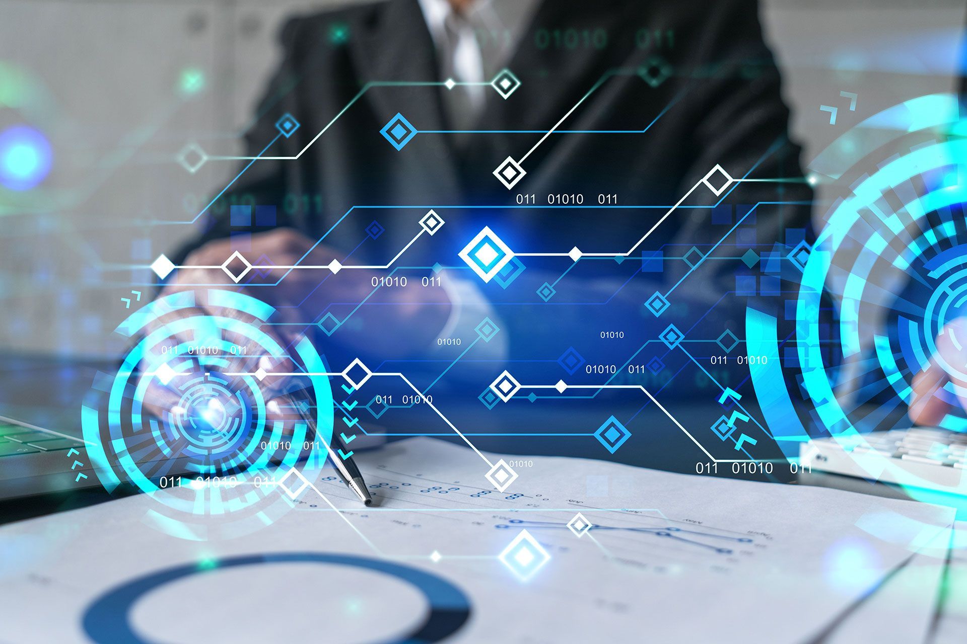 Businessman working at desk with digital graphics overlay.