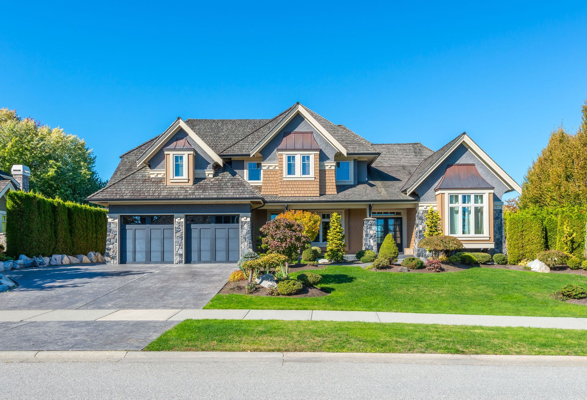 A large house with a lush green lawn in a residential neighborhood.