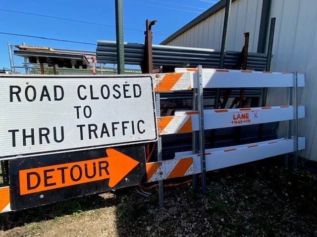 A sign that says road closed to thru traffic