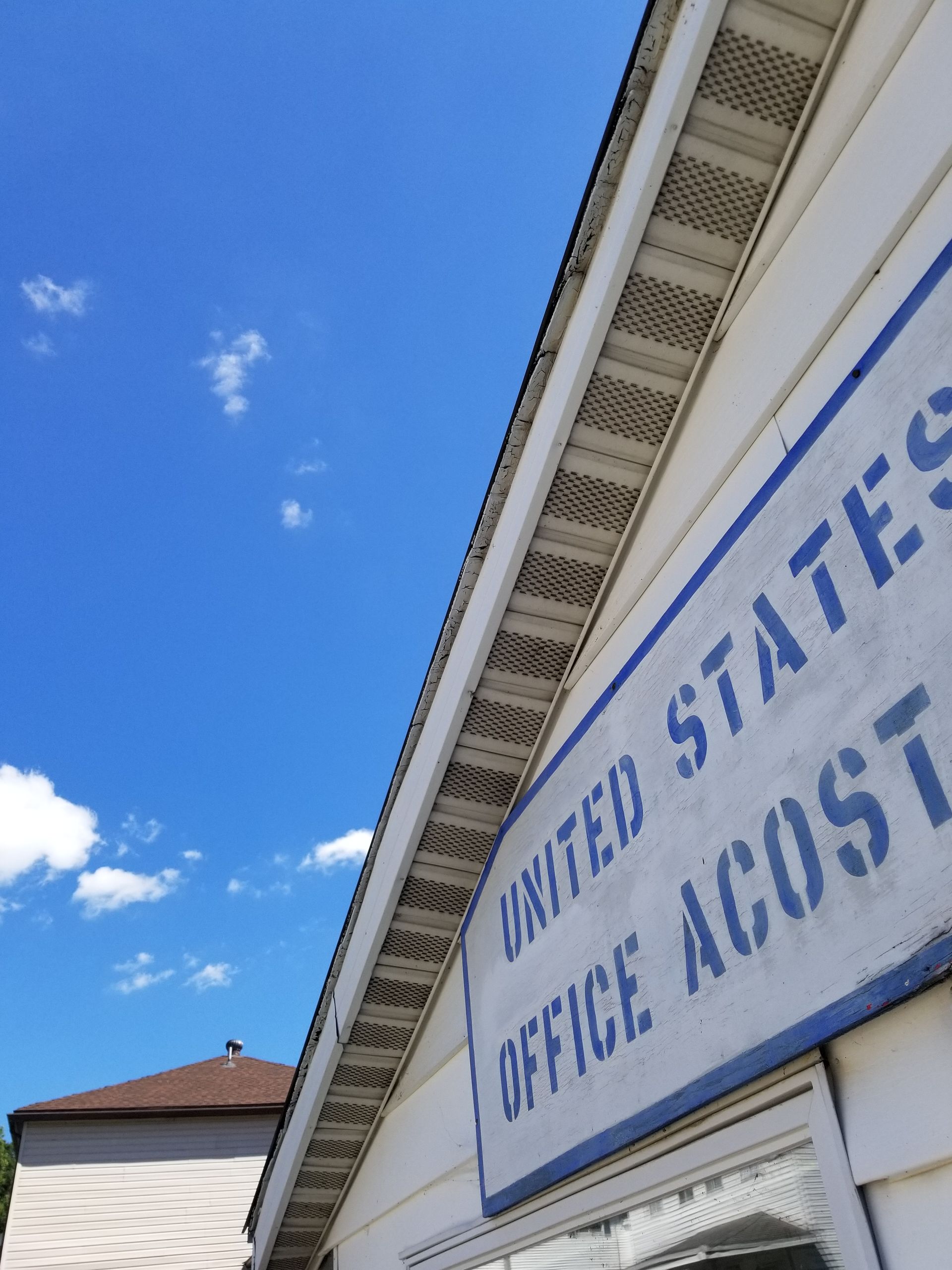 Blue sign on white building reads 