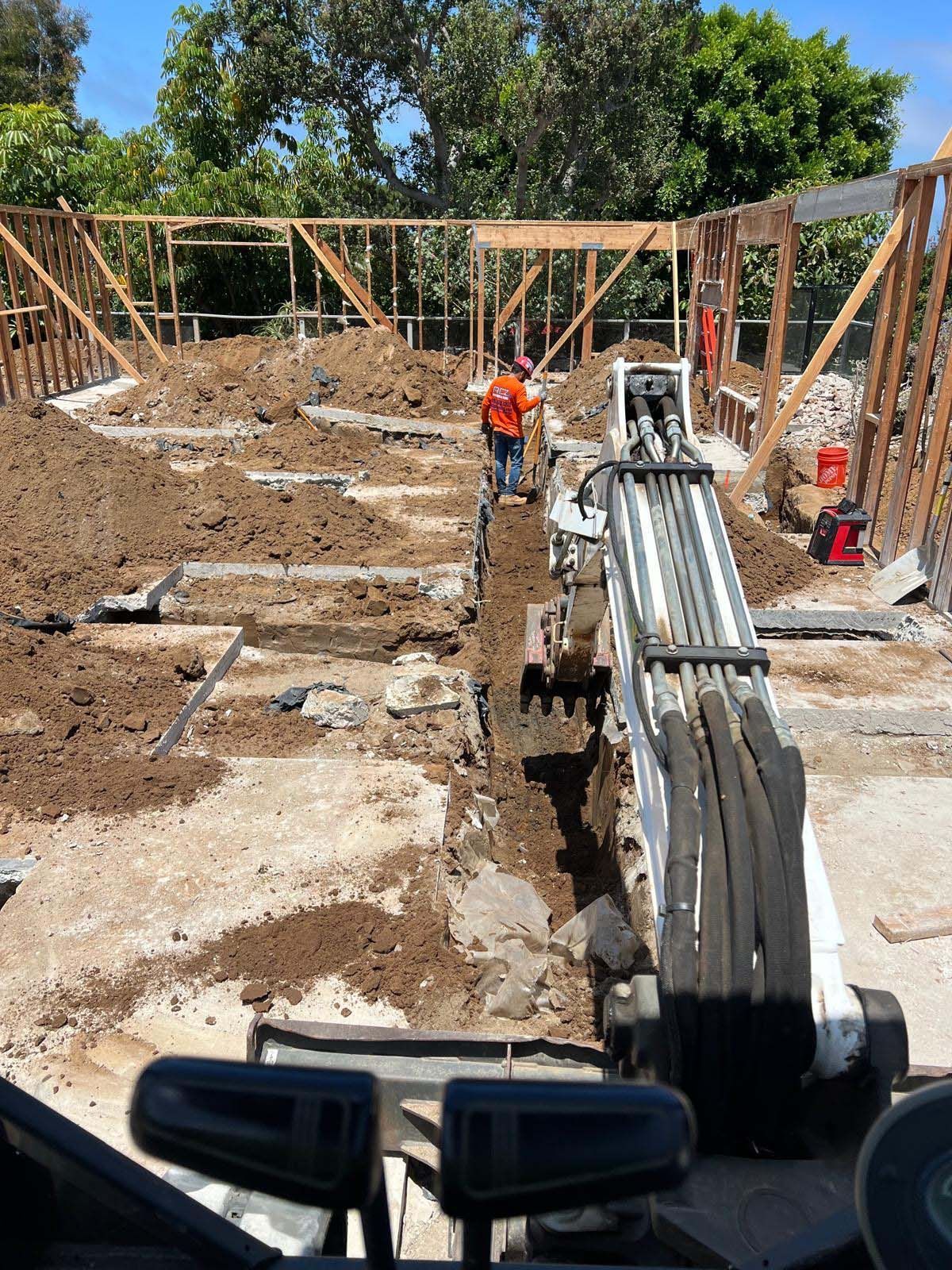 A construction site with a bulldozer and a man standing in the dirt