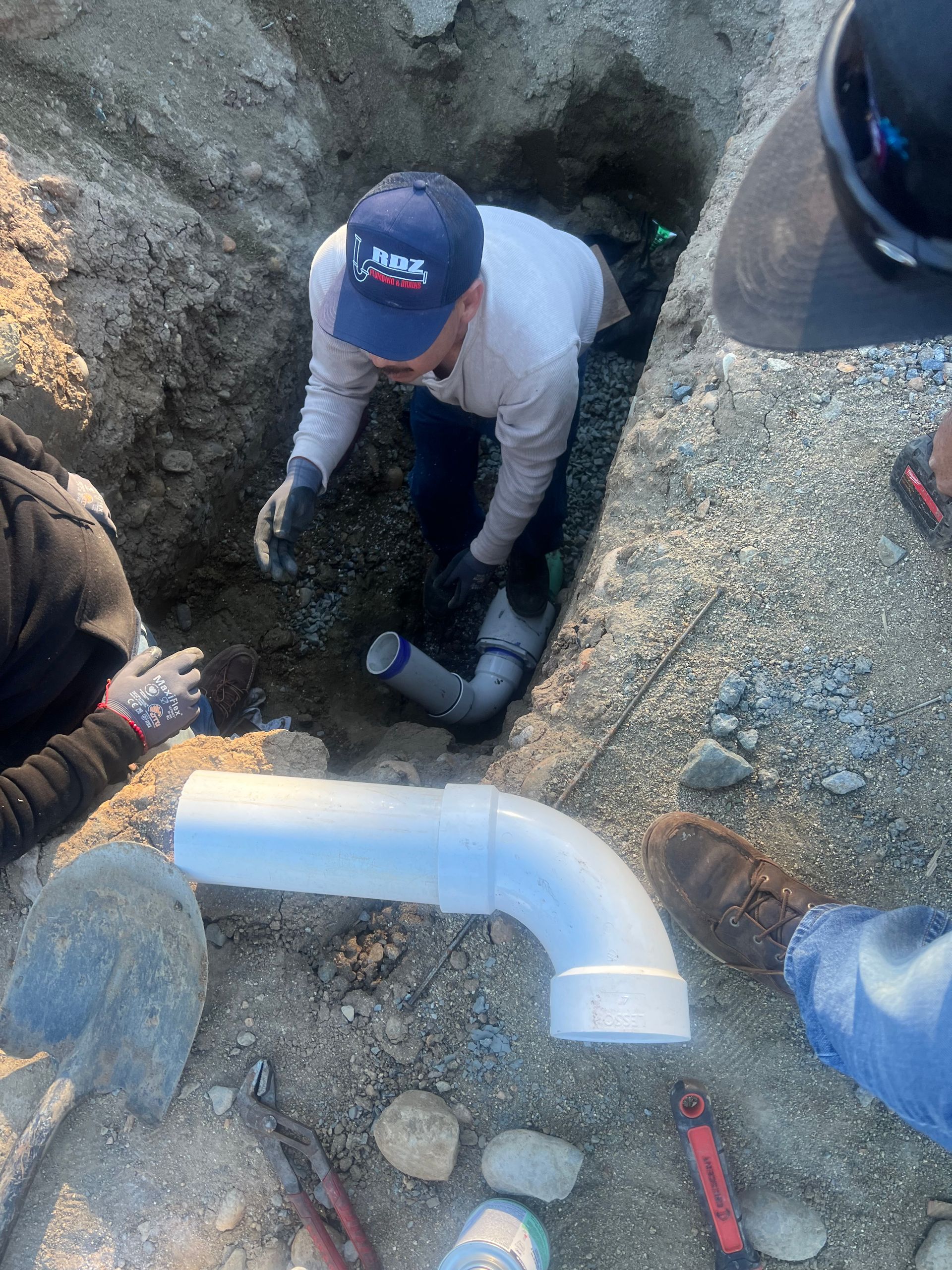 a man is working on a pipe in the dirt