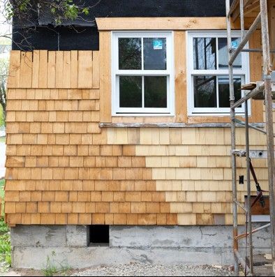 House exterior with fresh cedar shingles, two windows, and a scaffolding ladder on the right