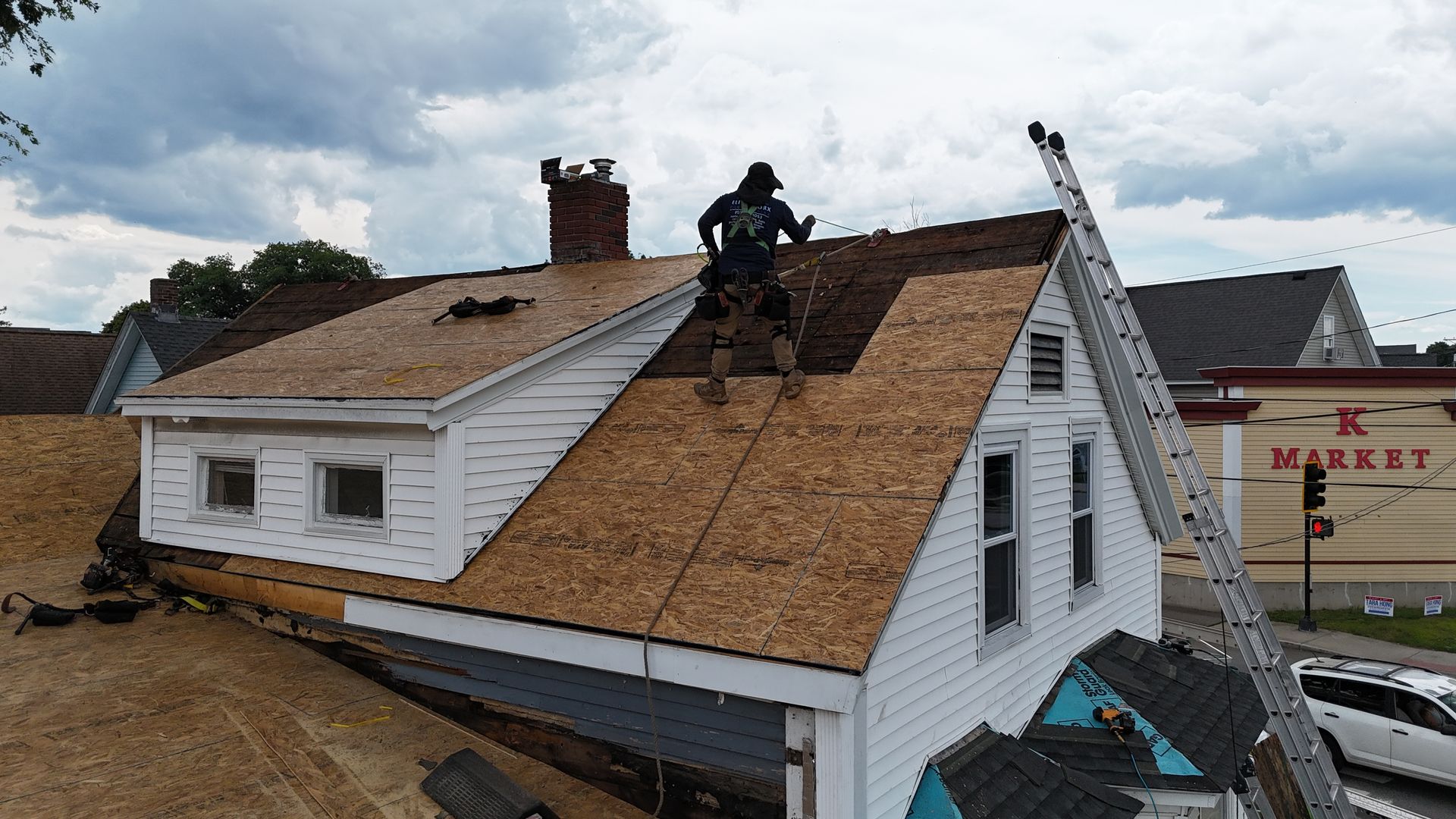 Roofers working on a house roof with new shingles during repairs