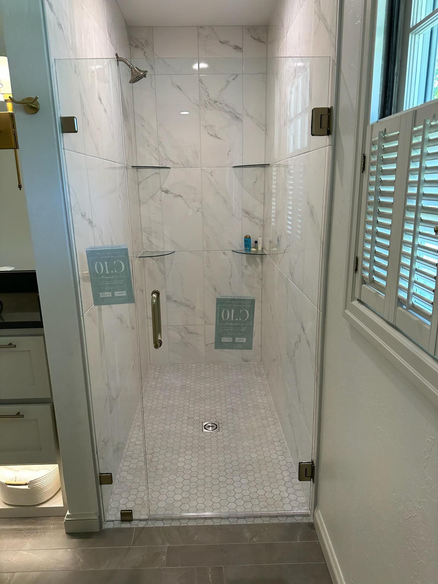 A bathroom with a walk in shower with a glass door.