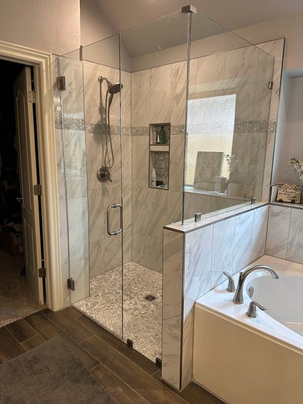 A bathroom with a walk in shower and a bathtub.