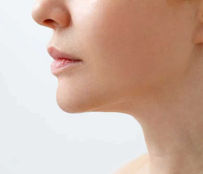 Profile view of a woman's face and neck, with smooth skin, soft features, and light coloring.