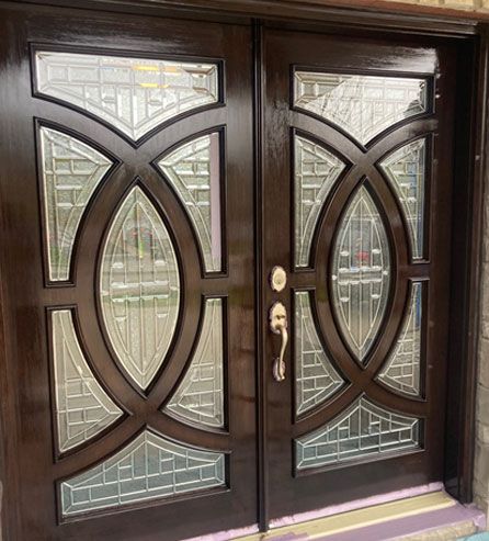 a pair of wooden doors with stained glass on them .