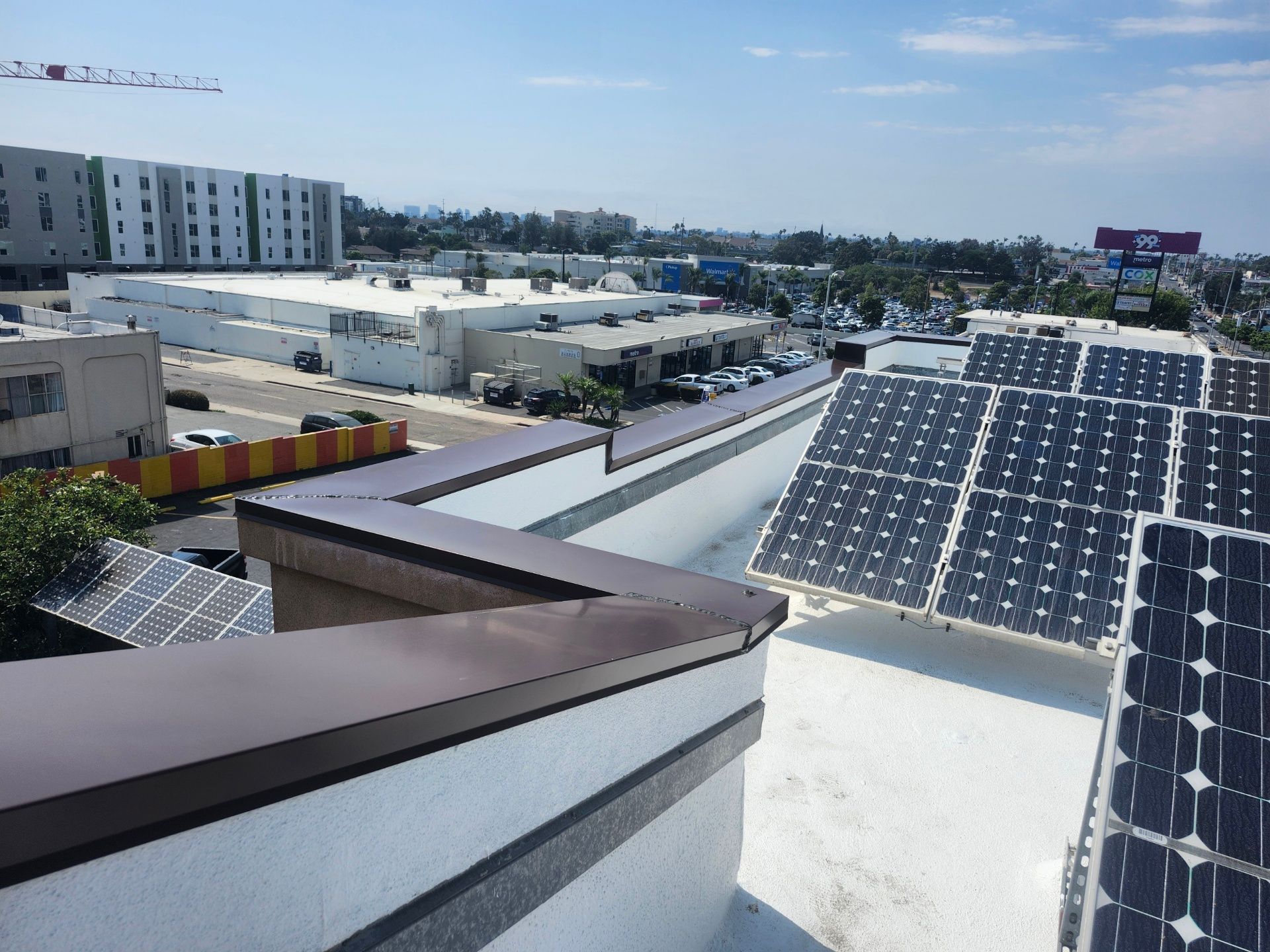 Rooftop solar panels overlooking an industrial area under a clear sky