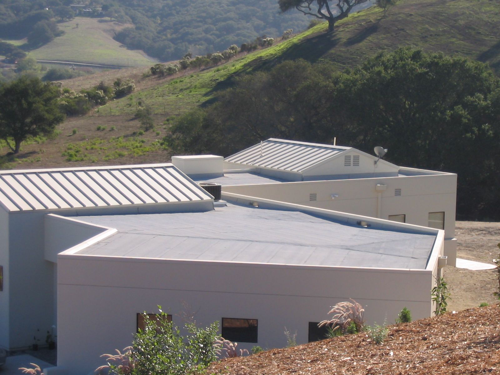 White-roofed house on a hillside with green valley views