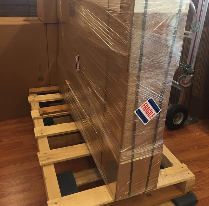 Large wrapped package on a wooden pallet, with a