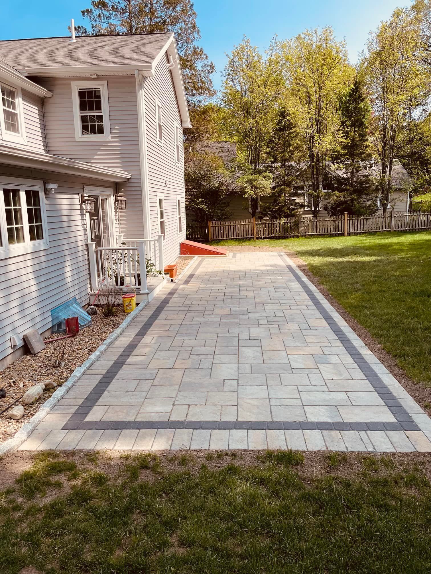 There is a brick walkway leading to the back of the house.